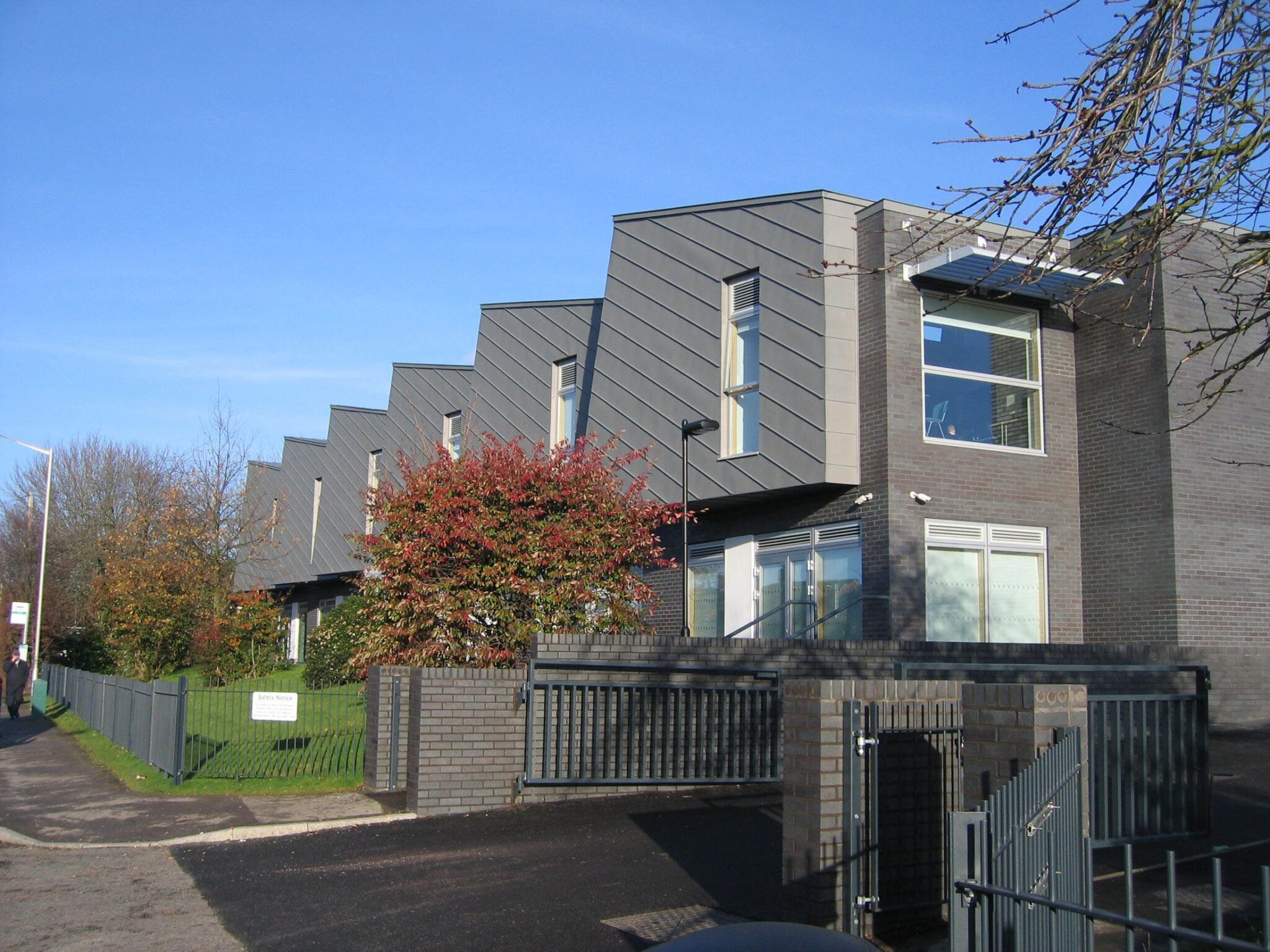 Reading Girls' School building with angled zinc roofline and brick boundary wall