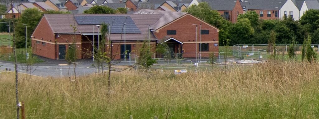 Meadow grasses in front of a new brick community building