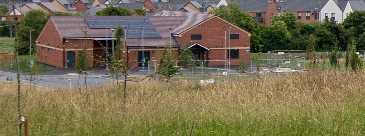 Meadow grasses in front of a new brick community building