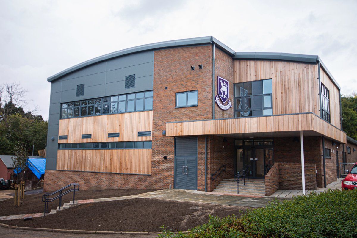 St Johns School sports hall with timber cladding and a curved roof