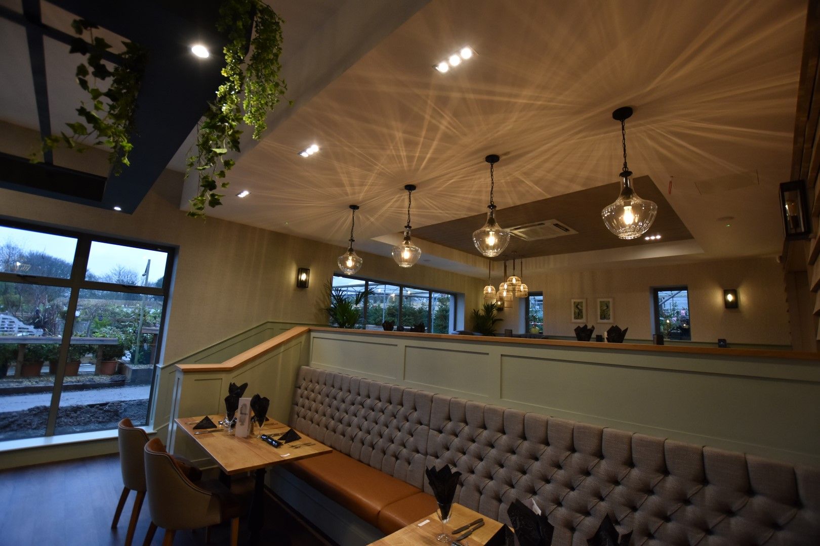 Restaurant interior at Warbeck Garden Centre with banquette seating and pendant lights